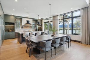 a kitchen and dining room with a large wooden table and chairs at Sisu Lodge by Canmore Premier in Kananaskis Village