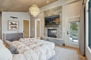 a large bed in a room with a stone fireplace at Sisu Lodge by Canmore Premier in Kananaskis Village