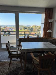 a dining room with a table and a large window at FeWo Luisa in Neureichenau