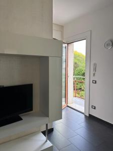a living room with a tv and a large window at Gerenz-home in Lecco