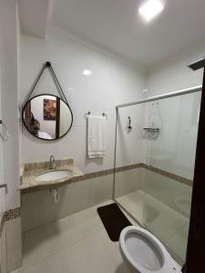 a bathroom with a toilet and a sink and a mirror at Espaço Physis in Vila Velha