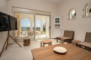 a living room with a tv and a table at Sandy Pines Villas in Alykes