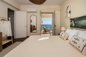a bedroom with a bed and a view of the ocean at Sandy Pines Villas in Alykes