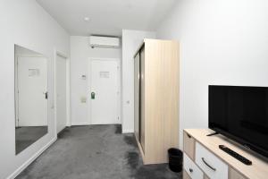a living room with a flat screen tv on a cabinet at In City Hotel in Yerevan