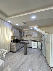 a large kitchen with a counter and a refrigerator at Al Salty in Tall ar Rāmah