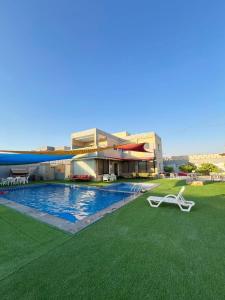 a resort with a swimming pool and a building at Al Salty in Tall ar Rāmah