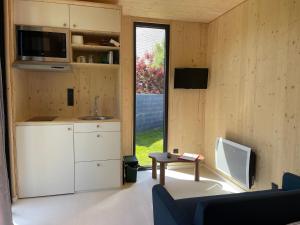 a room with a kitchen and a living room with a table at Chez Tib in Trégunc
