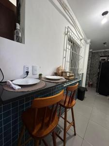 a kitchen with two chairs and a counter with plates on it at Espaço Physis in Vila Velha