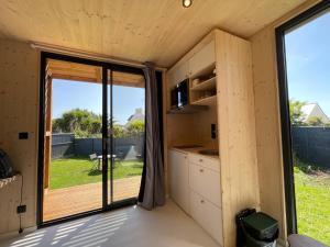 a small kitchen with a large sliding glass door at Chez Tib in Trégunc