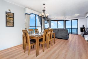 a dining room with a table and chairs and a bed at Sunset Sails Redcliffe in Redcliffe