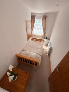 a small bedroom with a bed and a window at Flat White in Westward Ho