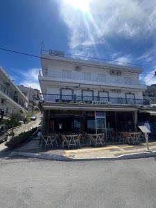a building with tables and chairs in front of it at Malama's apartment in Neos Marmaras