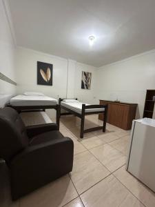 a living room with two beds and a couch at Espaço Physis in Vila Velha