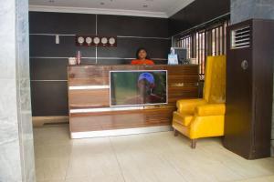 a woman standing behind a television in a room at Emglo Suite in Lagos