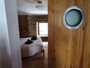 a bedroom with a bed with a mirror on the wall at Casa do Baloiço em Porto de Vacas Aldeias de Xisto in Janeiro de Baixo