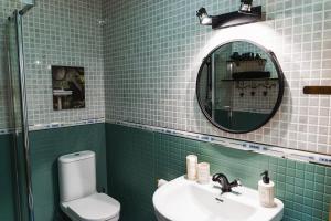 a bathroom with a sink and a mirror and a toilet at Apartamento amplio con gran terraza y vistas in Monachil +23 photos