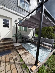 a patio with an umbrella and benches on a house at Notodden Luxe two-bedroom Apartment in Notodden