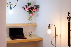 a desk with a laptop and a vase of flowers at El Fresquedal in Alozaina