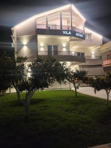 a lit up building with trees in front of it at Vila Astrit in Fier
