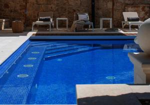 a large blue swimming pool with chairs in a building at Old Town Oasis in Dubrovnik