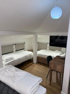 a room with two beds and a desk and a television at Vila Astrit in Fier
