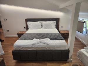 a bedroom with a large bed with white sheets and pillows at Vila Astrit in Fier +14 photos