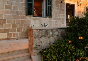 a house with a stone wall and a window with oranges at Old Town Oasis in Dubrovnik