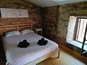a bedroom with a bed with two hats on it at Casa do Baloiço em Porto de Vacas Aldeias de Xisto in Janeiro de Baixo