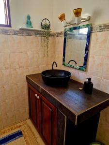 a bathroom with a black sink and a mirror at Beach House in Saly Portudal +25 photos