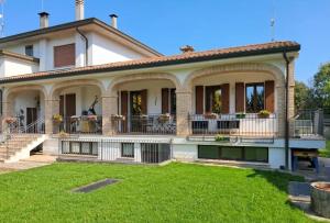a large white house with a green yard at Casa Il Sogno in Vazzola