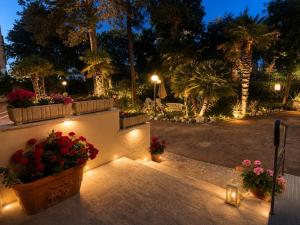 a garden at night with flowers and lights at Hotel Villa Pina in Senigallia