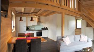 a living room and kitchen with a couch and a table at Ferienhäuser Ilsensee Schillingsfürst in Schillingsfürst