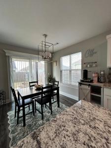 a kitchen and dining room with a table and chairs at NWA Modern Stay in Springdale