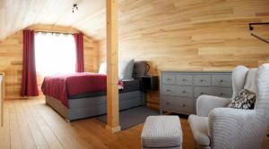 a bedroom in a log cabin with a bed and a window at Ferienhäuser Ilsensee Schillingsfürst in Schillingsfürst