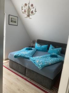 a bed with blue pillows in a room at Haus Else am Nationalpark Eifel in Schleiden