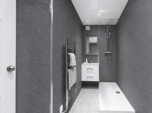 a bathroom with a shower and a sink at Dunallan Farm Cottage with Optional Hot Tub & Stunning Views in Island of Bute