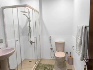 a bathroom with a shower and a toilet and a sink at Aura Downtown Suites in Cairo +21 photos