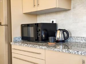 a black microwave on a counter in a kitchen at Aura Downtown Suites in Cairo