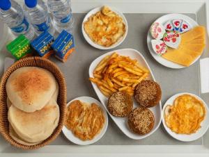a table topped with plates of food and french fries at Aura Downtown Suites in Cairo