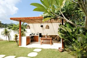 a backyard kitchen and living area with a pergola at Promo - Private 1BR villa for couples in Kuta Lombok