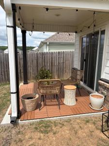 a patio with two chairs and a bench on a deck at NWA Modern Stay in Springdale