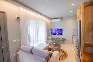 a living room with a couch and a table at Maresol Villa in Nea Kallikrateia