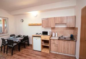 a small kitchen with a table and a table and chairs at NiKi in Patince