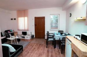 a kitchen and living room with a table and chairs at NiKi in Patince