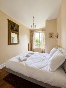 a bedroom with a bed with white sheets and a window at Château de Luzières in Conty