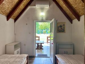 a bedroom with two beds and a door to a patio at Camping Lukač in Kutina