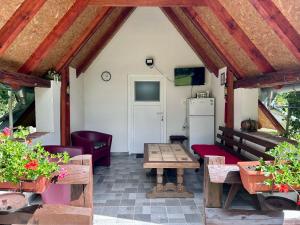 a screened in porch with a table and a refrigerator at Camping Lukač in Kutina