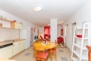 a kitchen and dining room with a wooden table and chairs at Apartment Seaside Peace in Vela Luka +20 photos