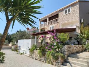 a house with flowers in front of it at Apartment Seaside Peace in Vela Luka