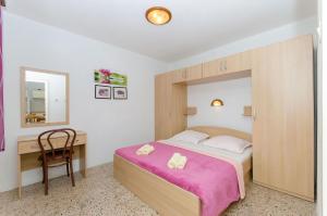 a bedroom with a bed and a desk with a chair at Apartment Seaside Peace in Vela Luka